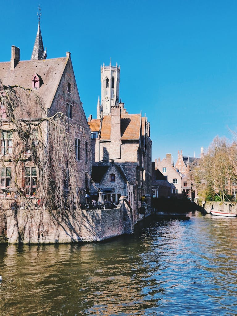 Picturesque canal view in Bruges, Belgium with iconic Belgian architecture.
